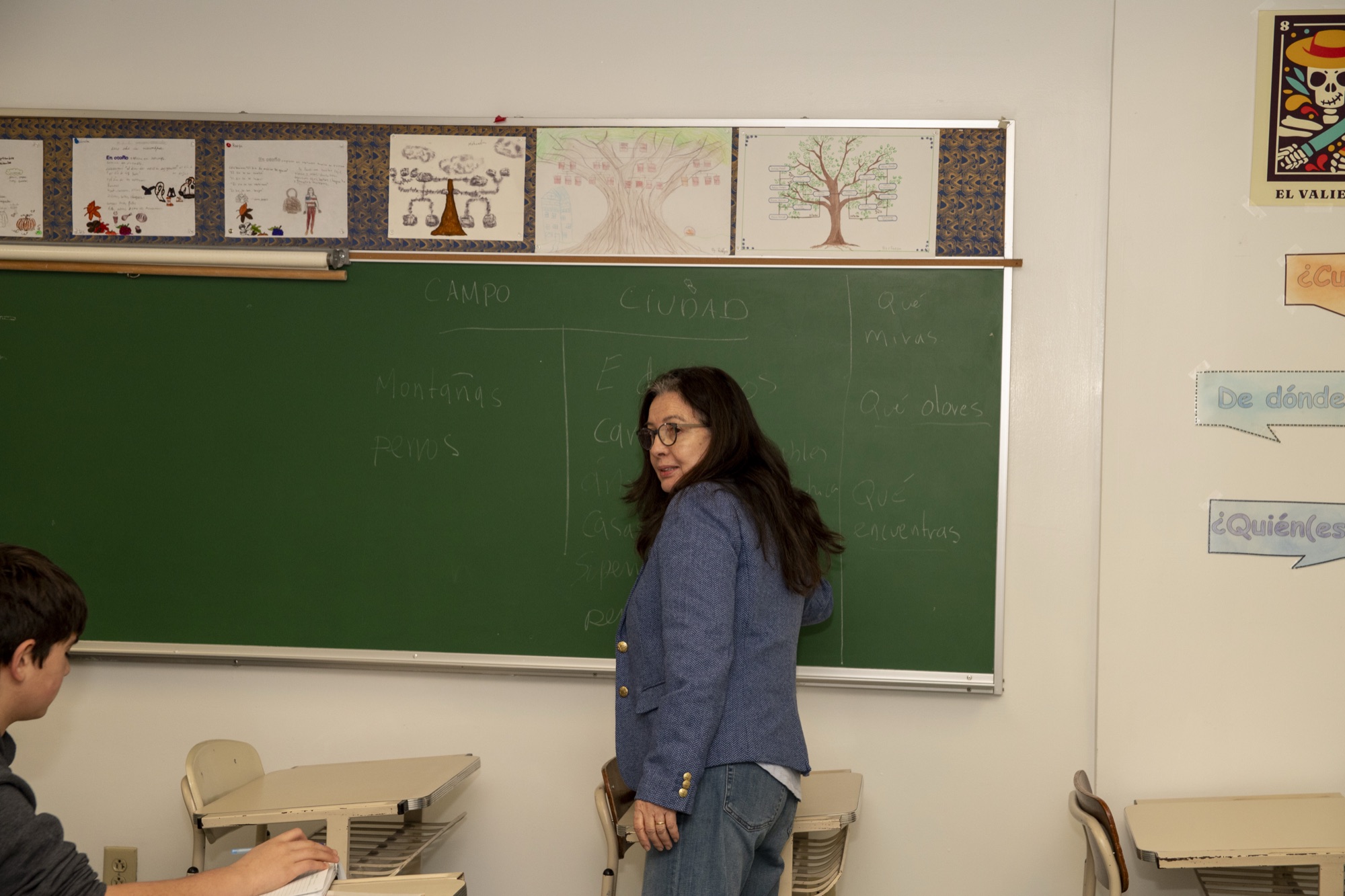 A Hudson School teacher leading an engaged classroom discussion at the board