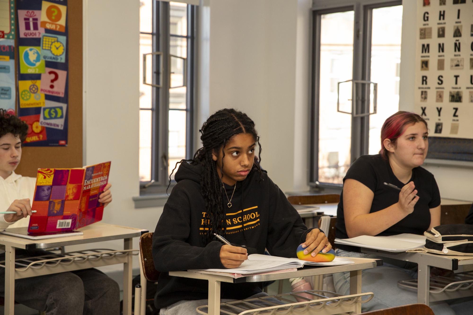 Wide bright classroom with multiple students at desks at The Hudson School