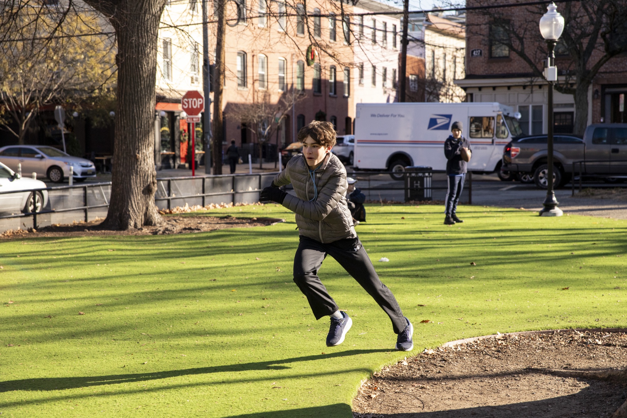 Hudson School student athlete leaping across an open park lawn