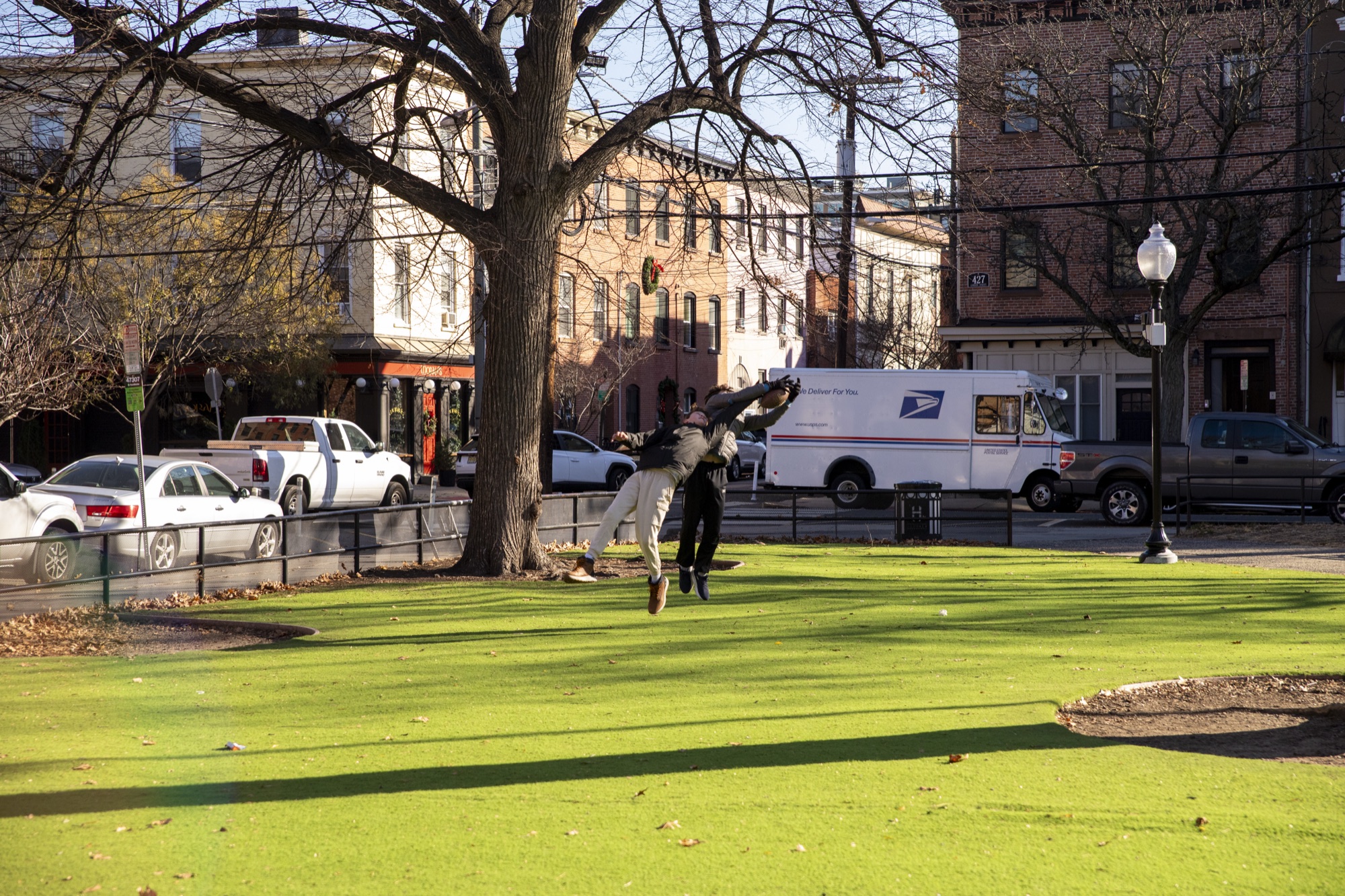 Hudson School students playing soccer on a sunlit park lawn in Hoboken