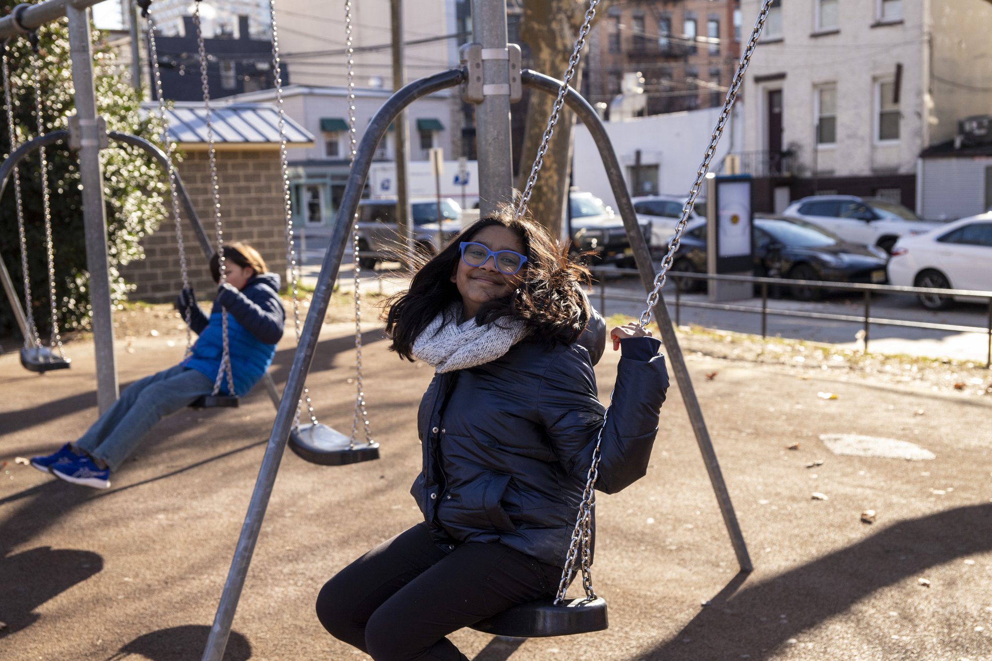 Two young girls swinging together side by side