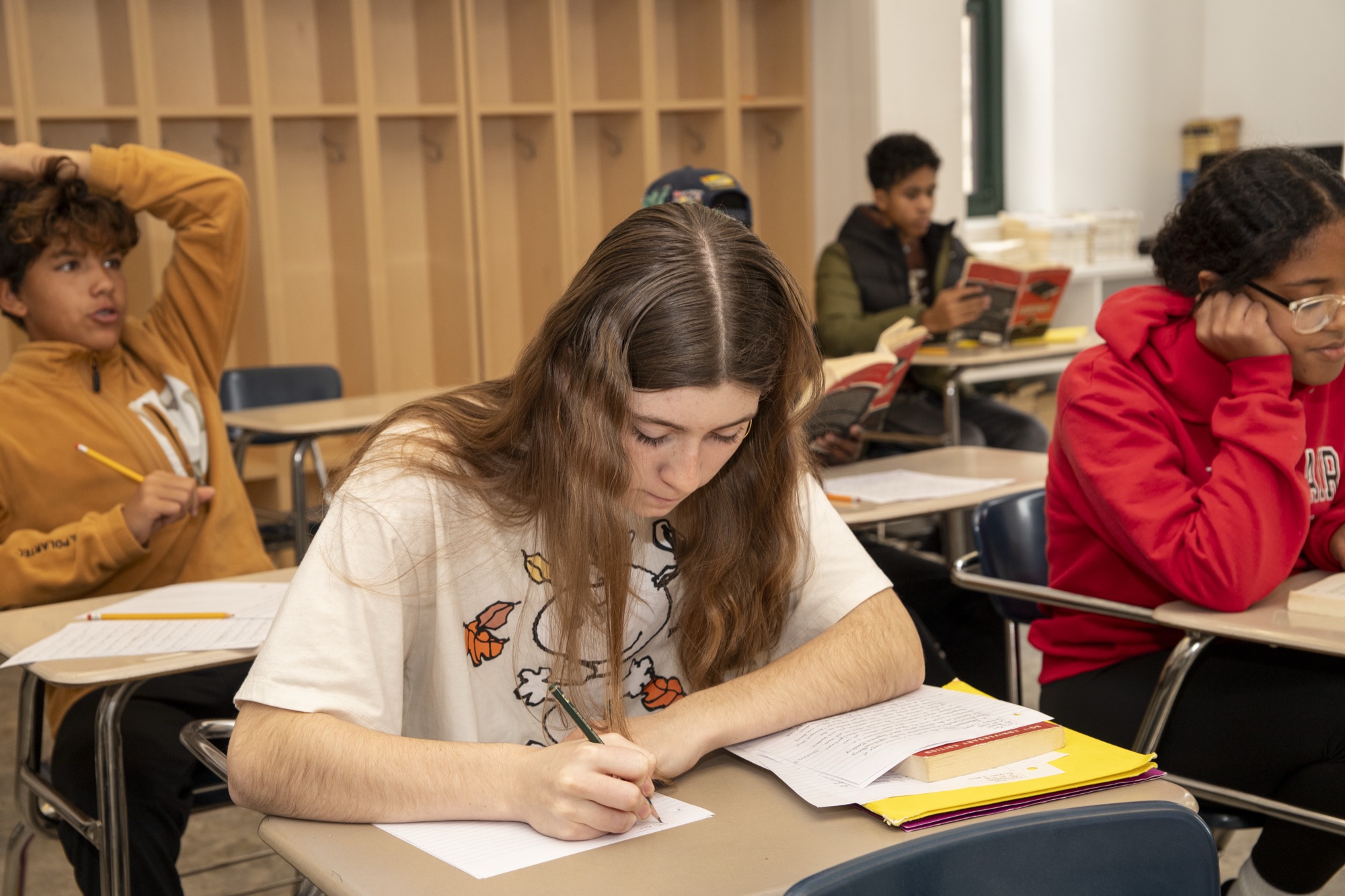 High school students writing in a bright modern classroom at The Hudson School