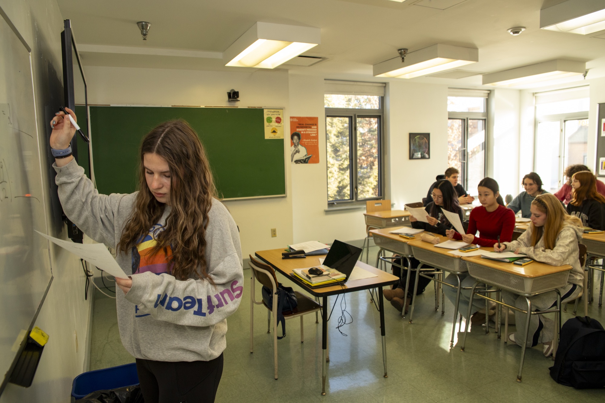 A Hudson School teacher engaging students in a bright classroom setting