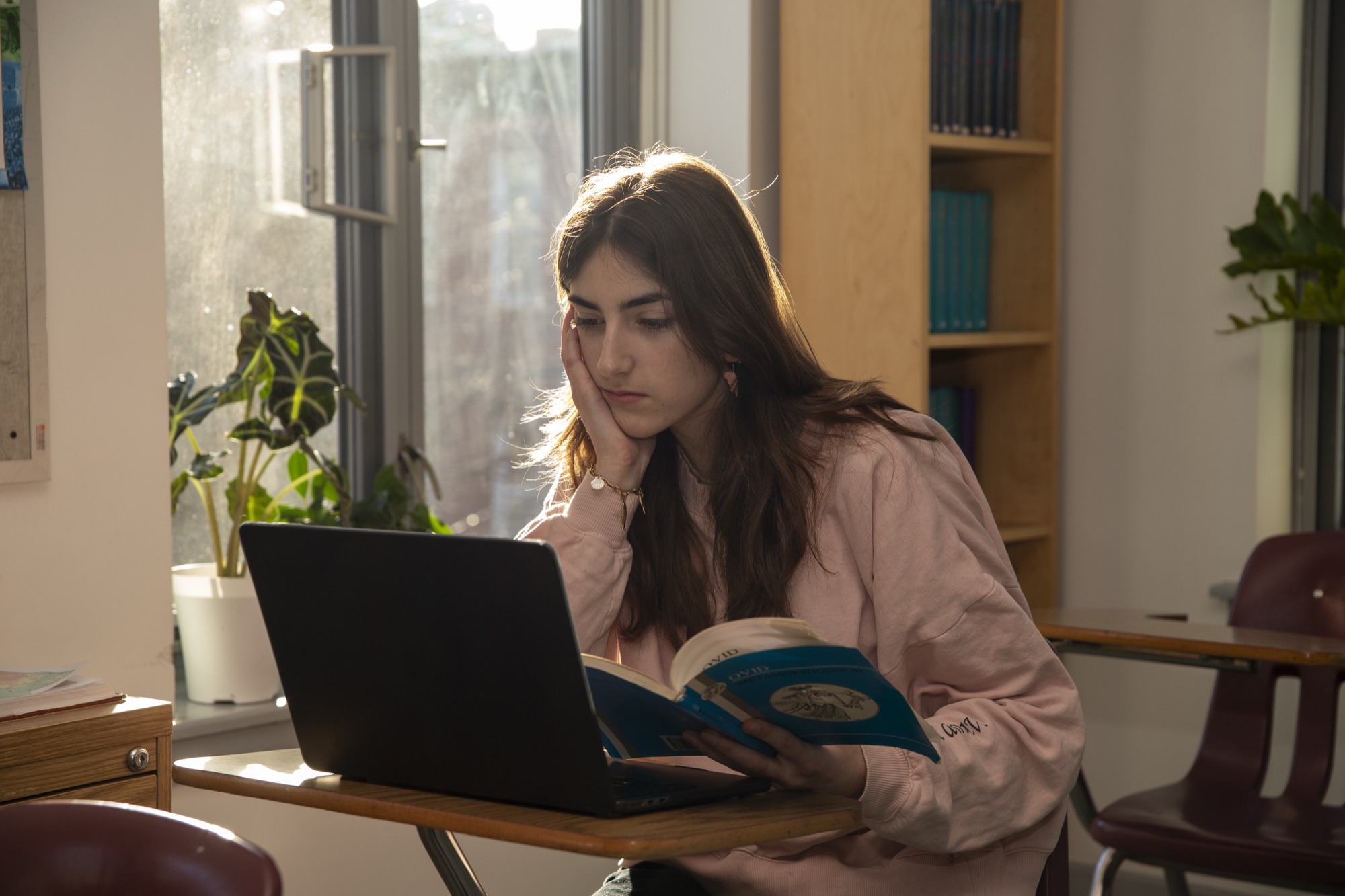 Student working at a laptop in a sun-filled Hudson School classroom