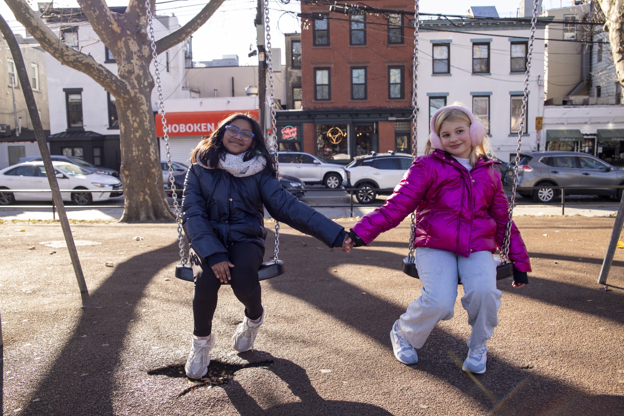 Young students jumping rope outdoors in front of Hoboken brownstones